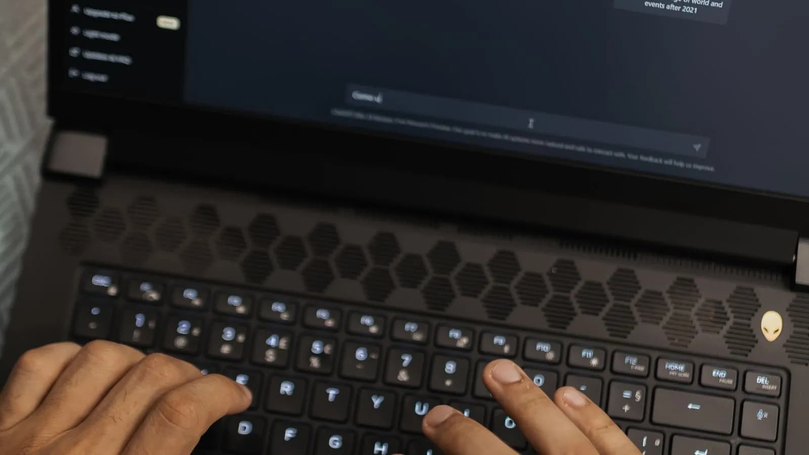 Hands typing on a laptop with an AI chat assistant on screen