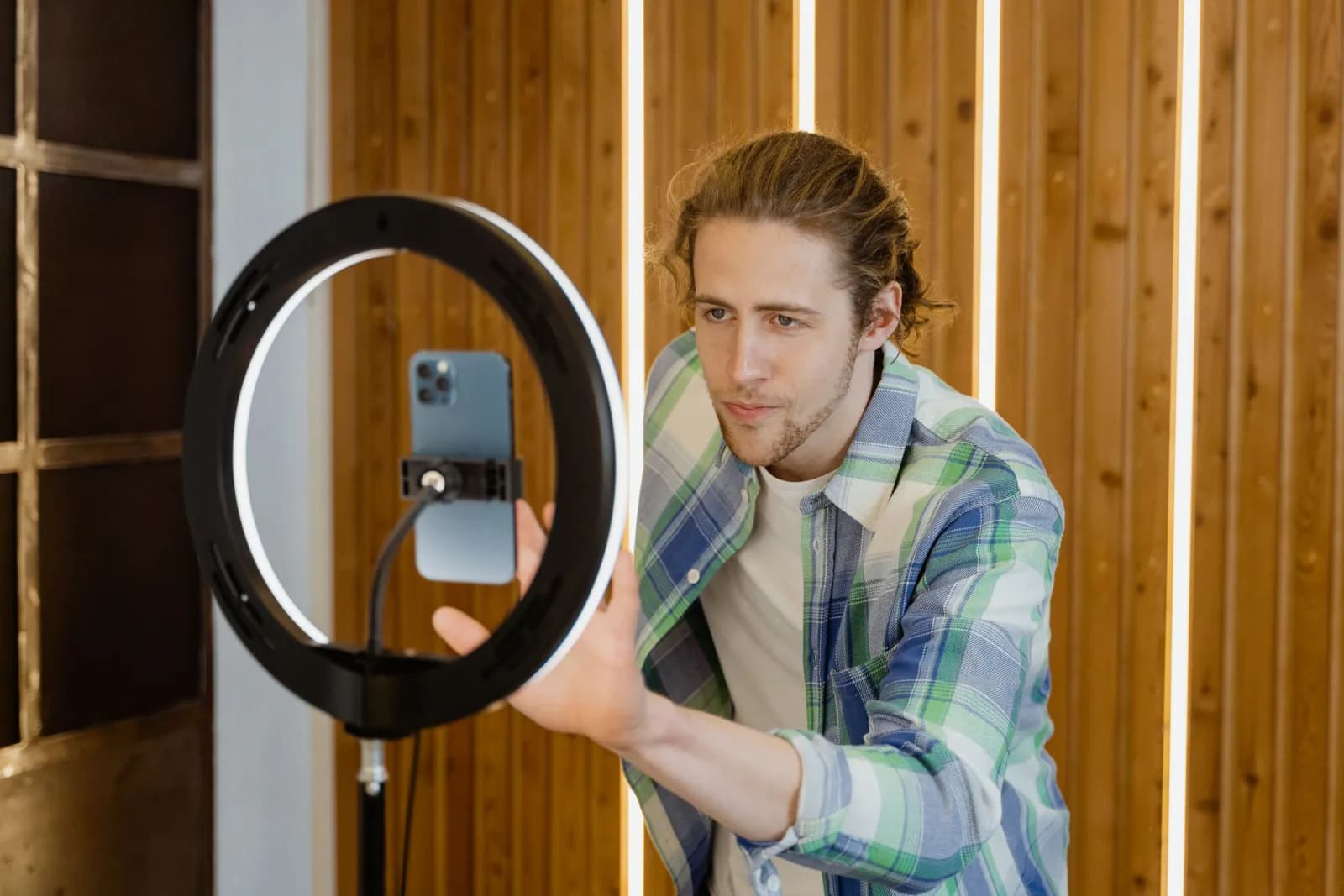A man setting up a smartphone on a ring light to record a video